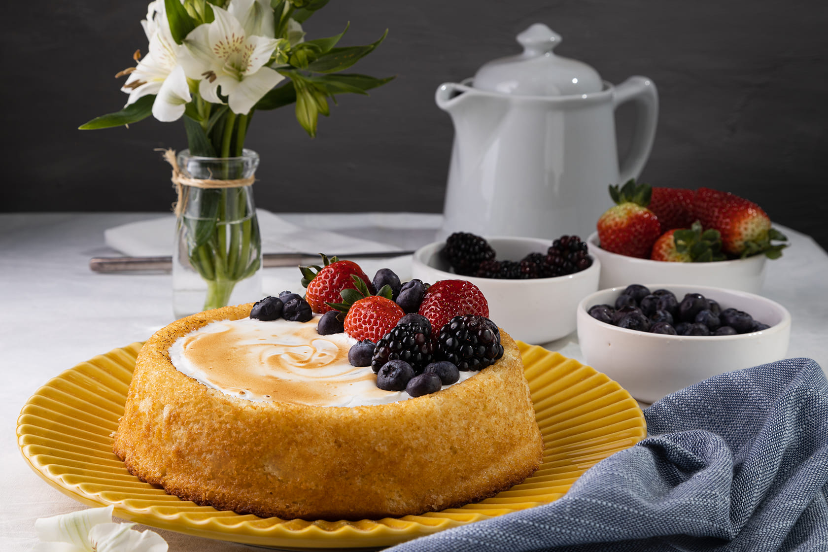 Mesa posta com bolo flores e frutas